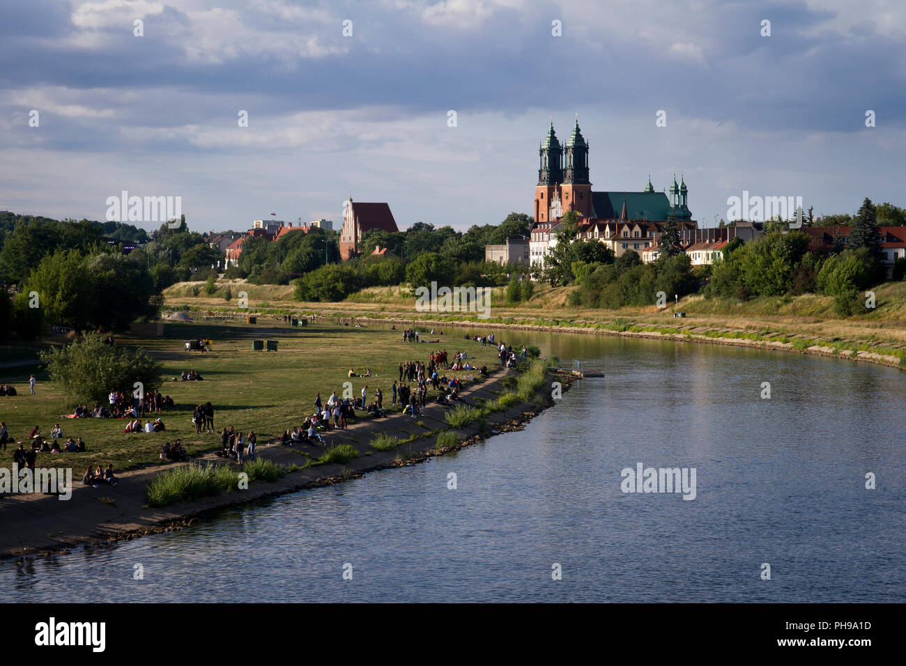 Young people during their rest on the Warta River in Poznań. Cathedral Island (Ostrow Tumski) in background. Stock Photo
