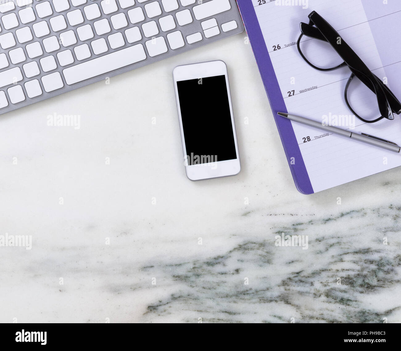 Marble desktop surface with calendar and other office objects Stock Photo