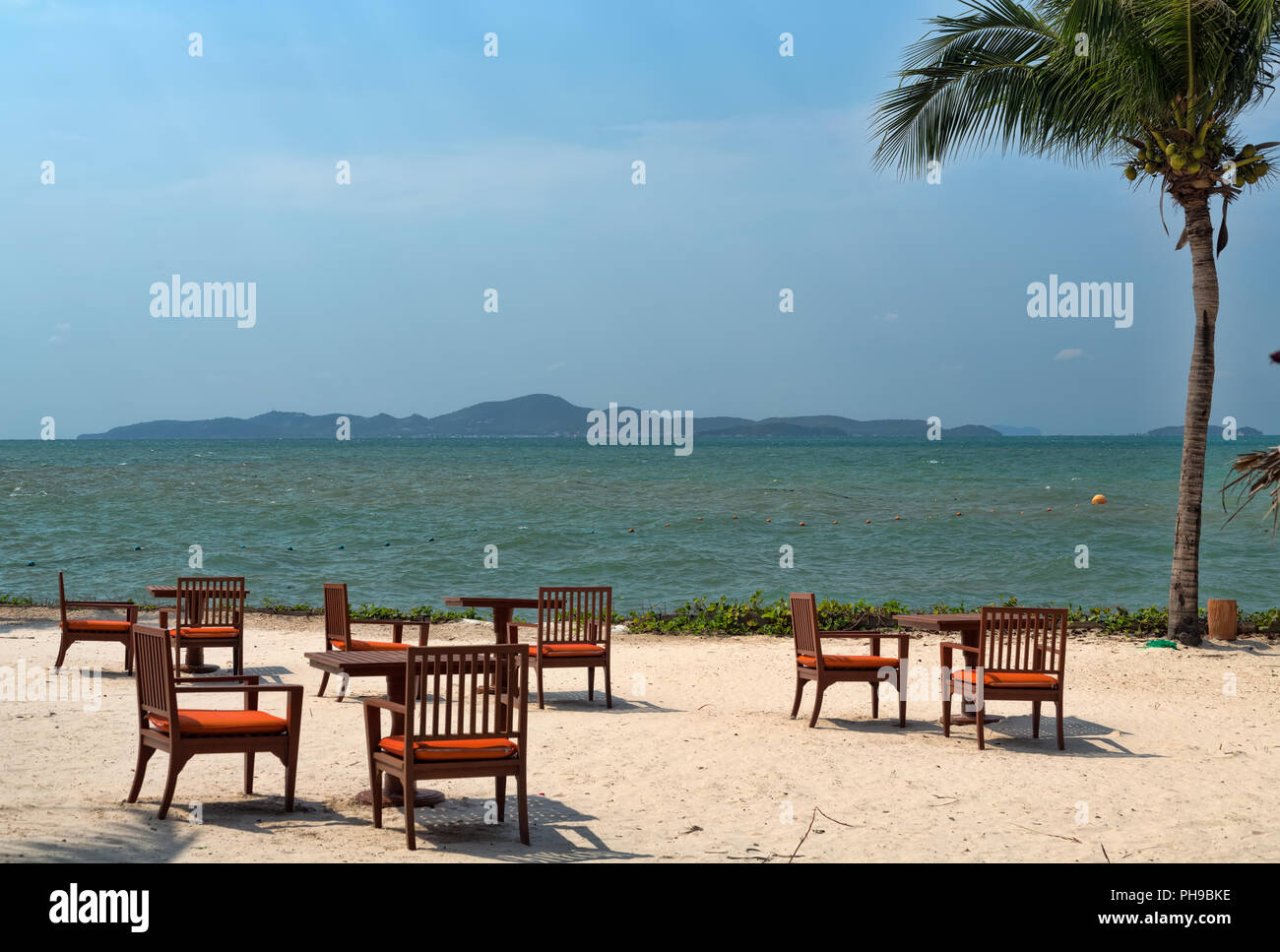 Tables on the beach with palm tree Stock Photo Alamy