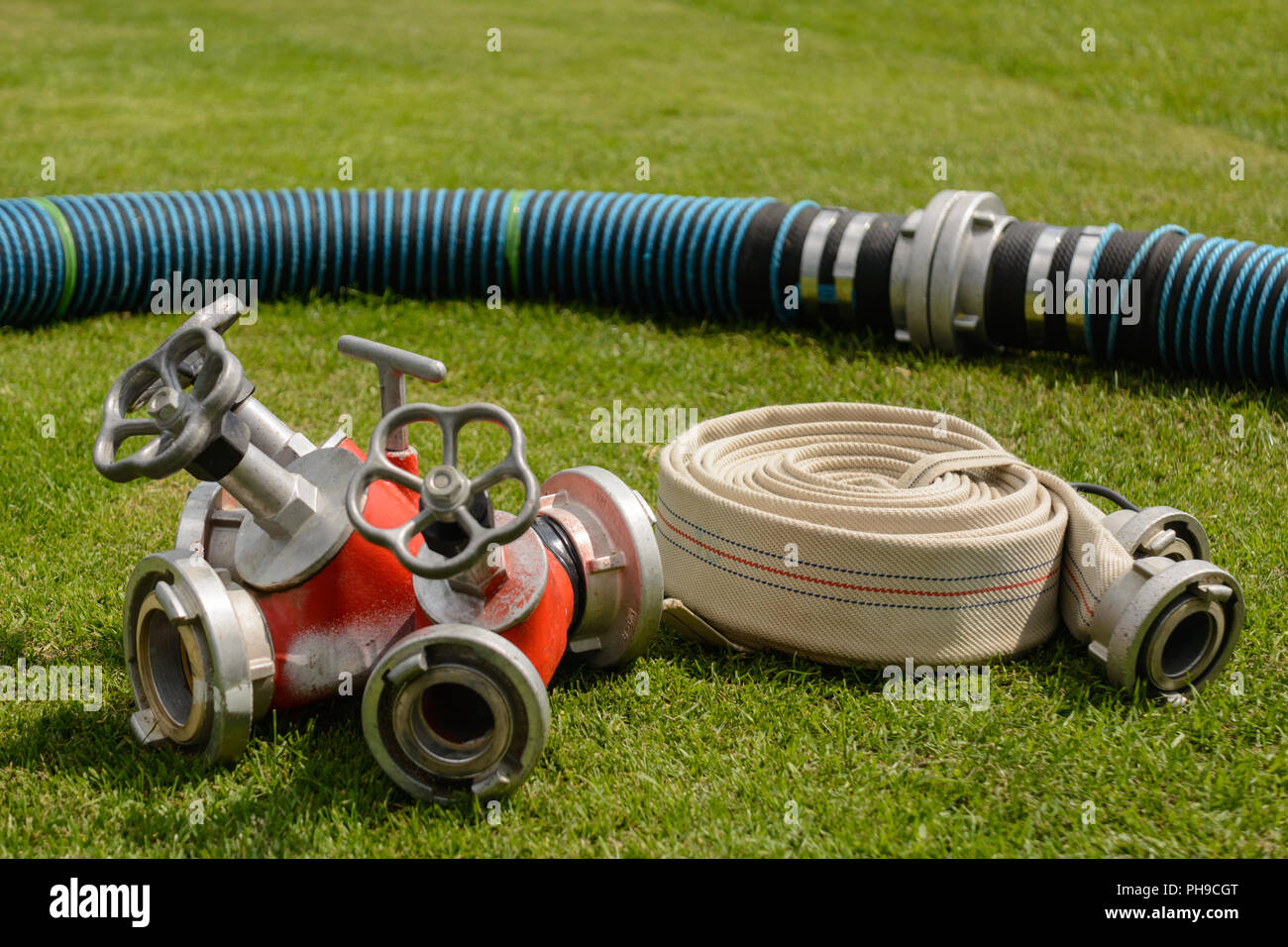 Rolled fire hose with coupling and distributor - close-up Stock Photo