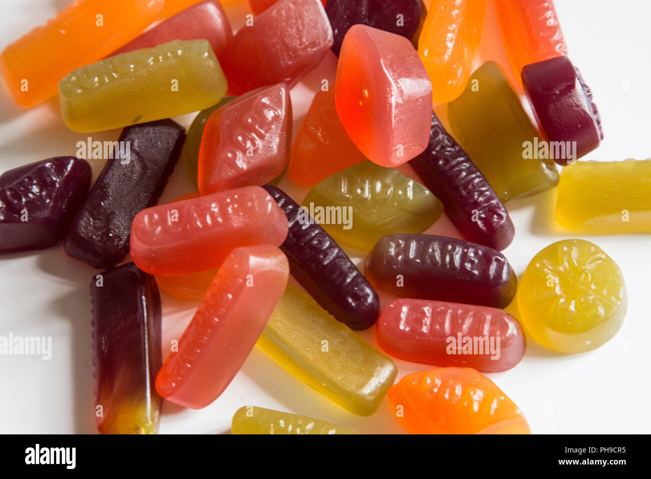 A pile of multi coloured wine gum sweets sitting on a white background, wine gums waiting to be eatten, Wine Gums Stock Photo