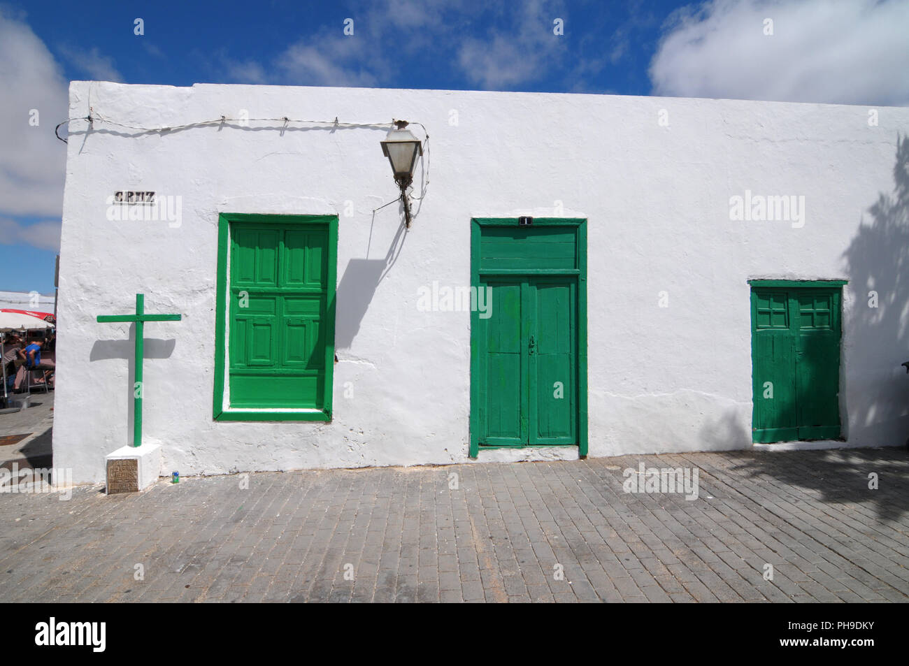 Old Church with green doors on a white wall Stock Photo