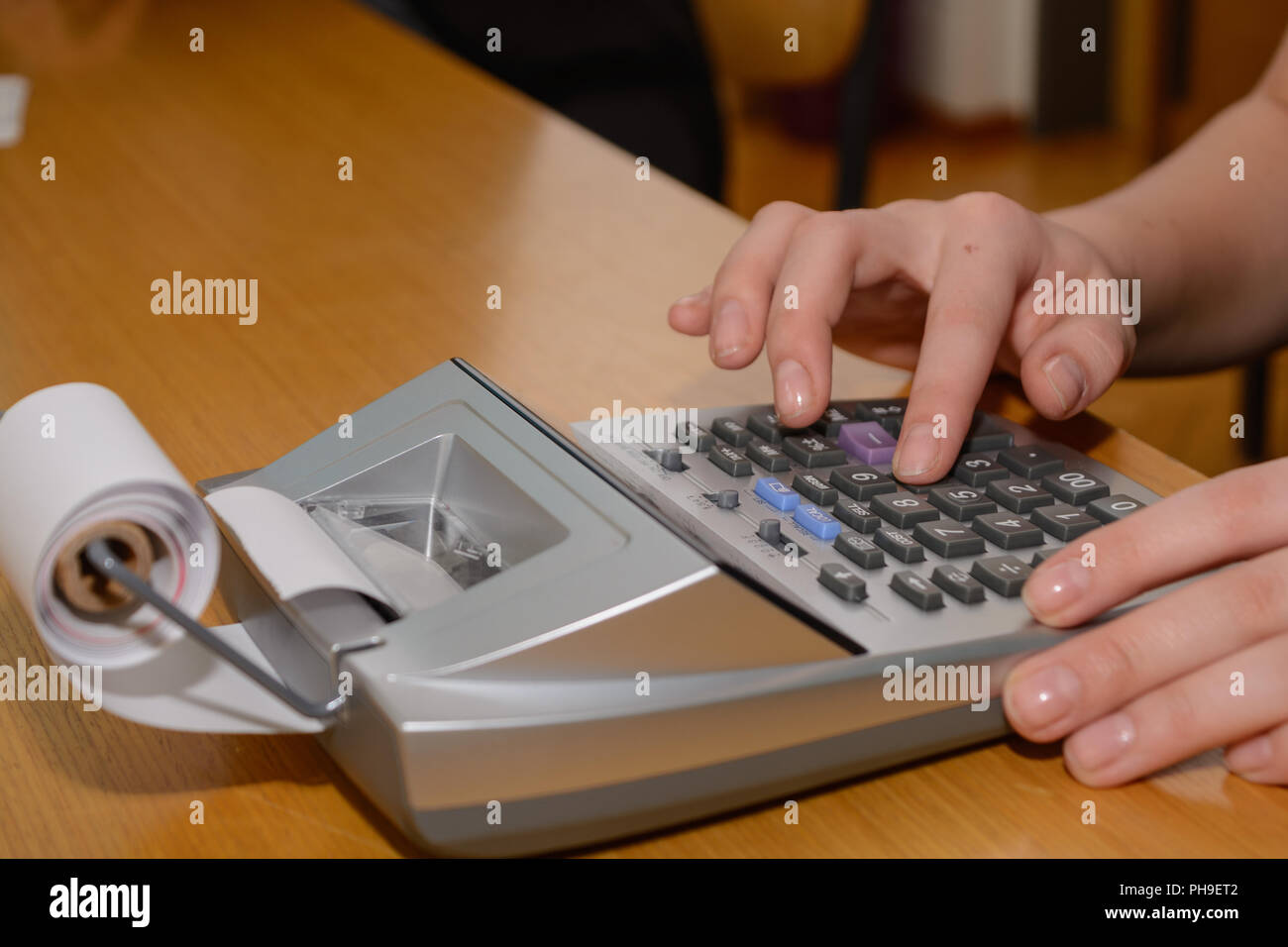 Office worker expecting with printing pocket calculator - close-up Stock Photo
