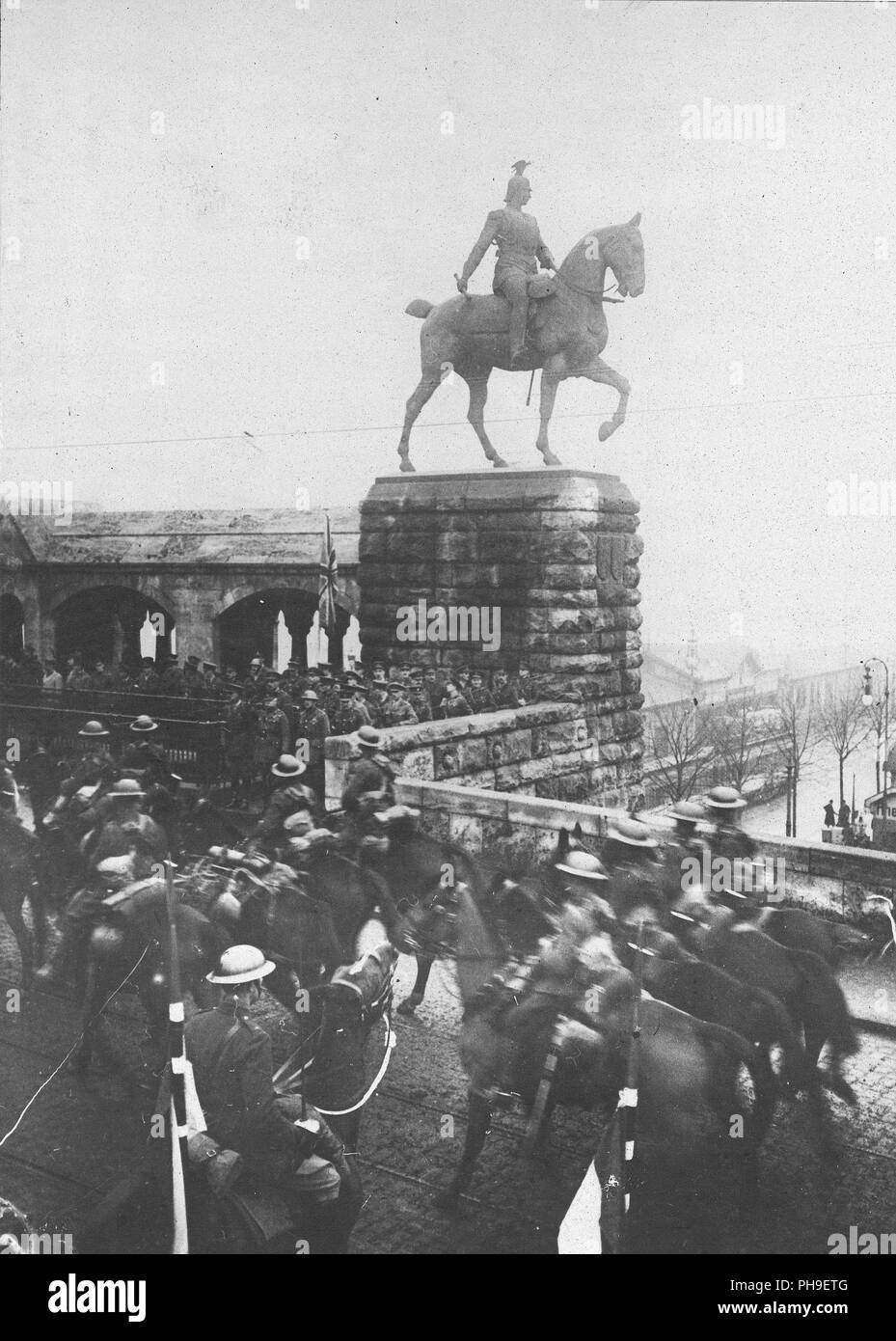 1919 - Kaiser watches British Army pass into Cologne. General Plumer, commander of the 2nd British Army with staff alongside the statue of the Kaiser, reviewing his cavalry as they cross the Hohenzollern Bridge at Cologne Stock Photo