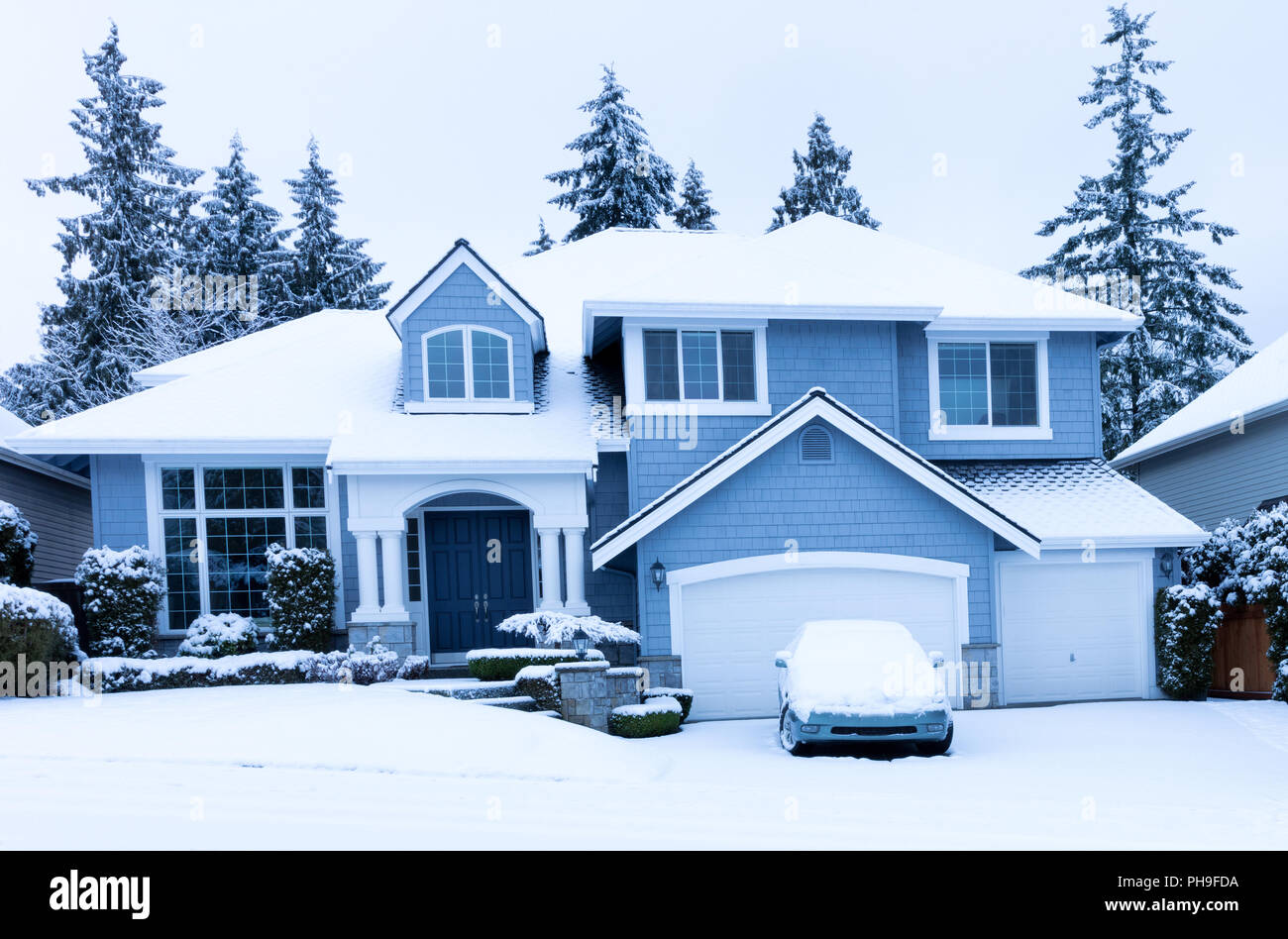 Front view of home during winter snowfall Stock Photo