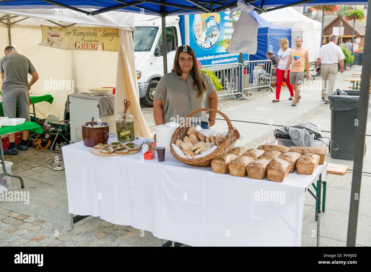 Girl selling local organic bread and lard sandwiches with pickled cucumbers at the street market in Krosno, Poland Stock Photo