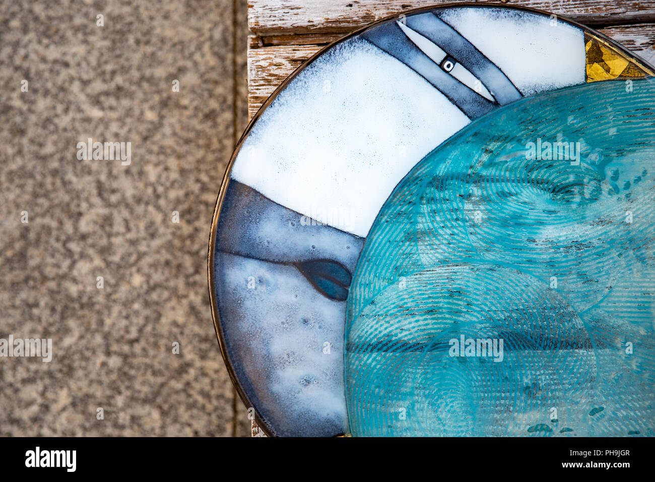Artistic glass plates laying on a wooden table. Krosno, Poland. Concept Stock Photo