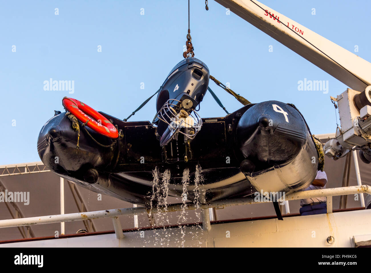 Empty inflatable boat being hoisted onboard the Lindblad National Geographic Islander in the Galapagos Islands. Stock Photo