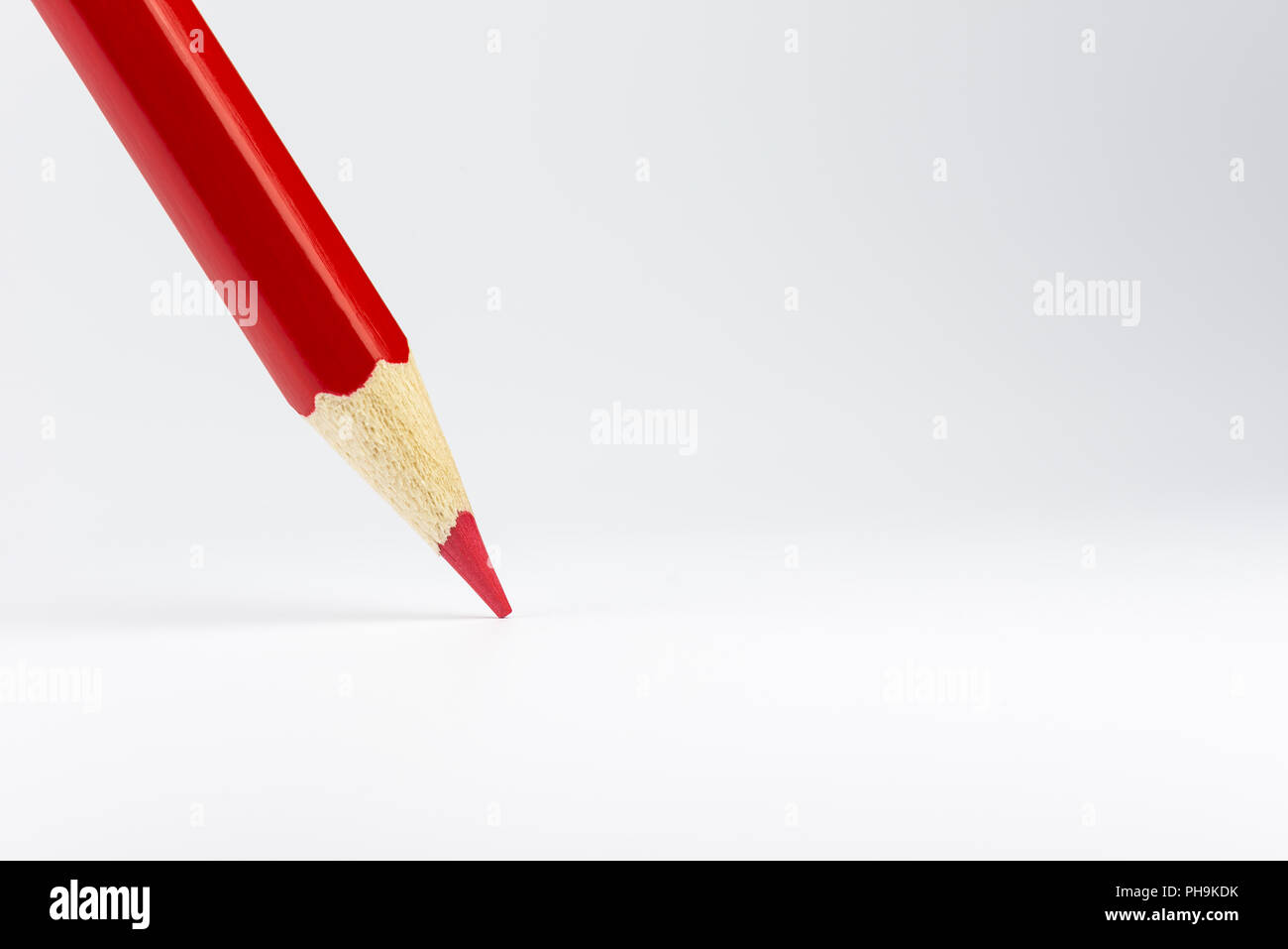 Standing red colored pencil on a white background Stock Photo