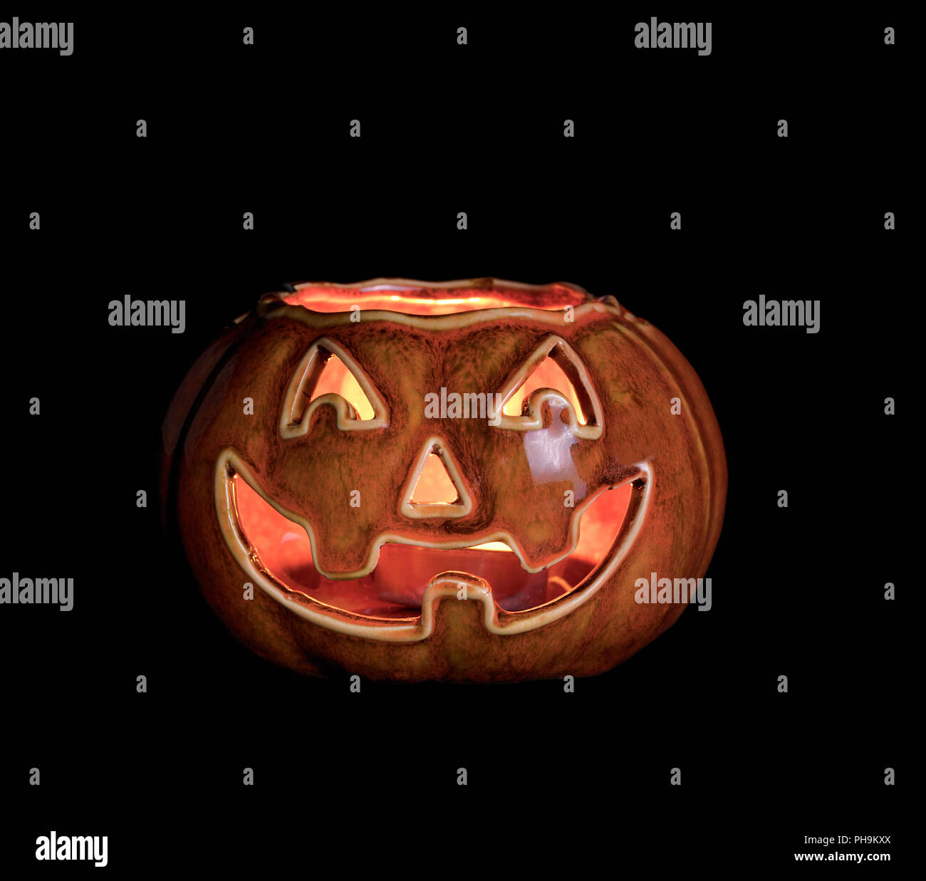 Glowing scary pumpkin decoration isolated on black background Stock Photo