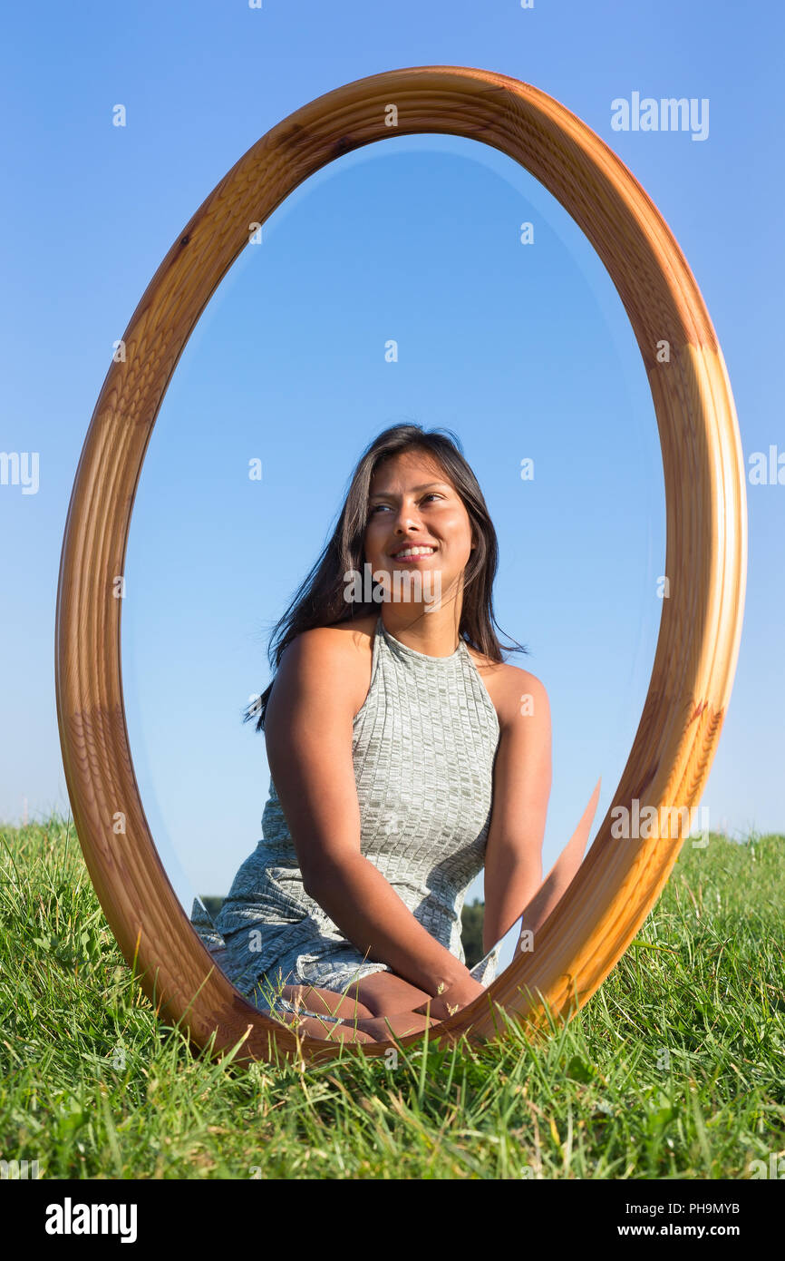 Mirror in grass with mirror image of woman Stock Photo