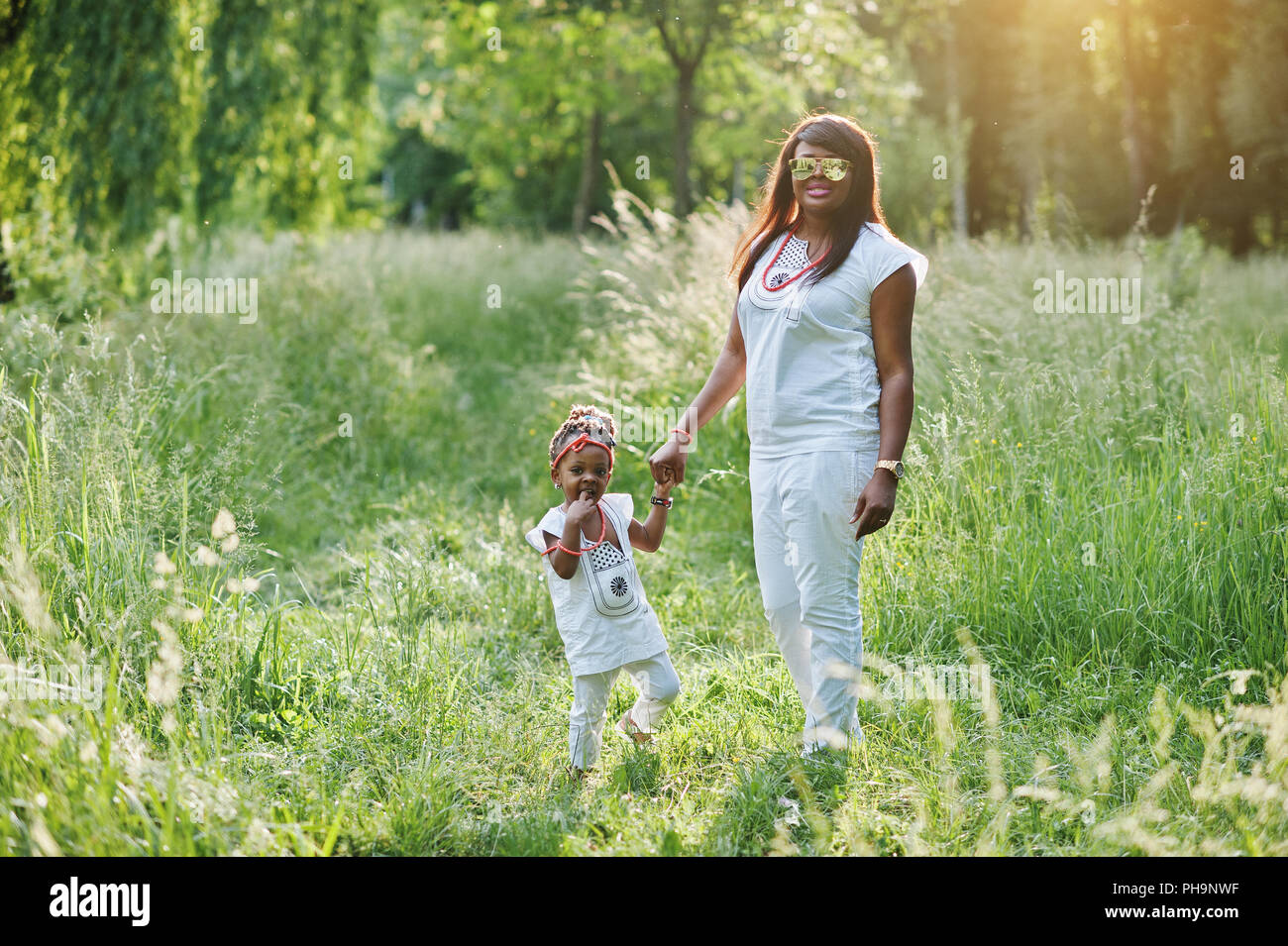 Black mother and daughter holding hand at park Stock Photo
