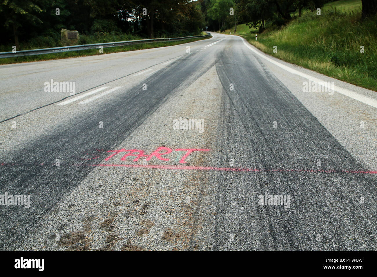 The rubber tracks from the racing cars left on the tarmac at the start of the hill climb stage. Stock Photo