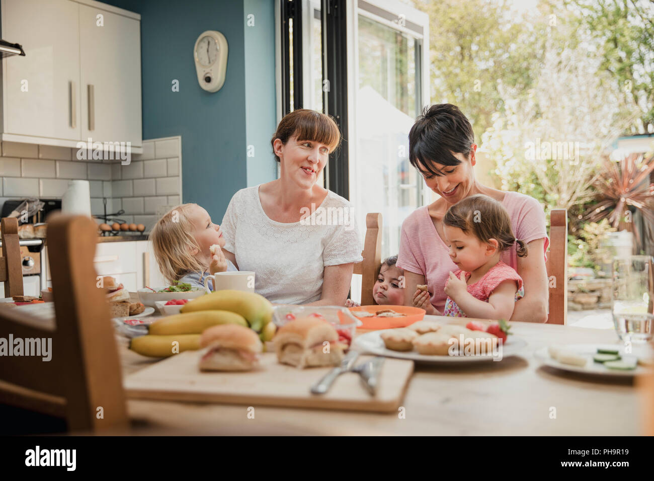 Еду маму друга. Мама сидит на кухне. Несколько женщин сидят на кухне. Семья за обеденным столом две Дочки фото. Родители на кухне сидят.