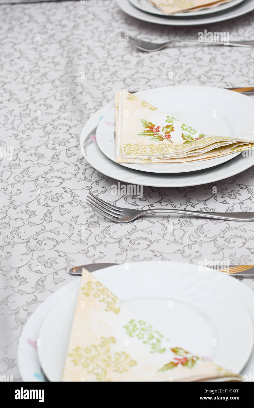 cutlery and plates with napkin on the table Stock Photo