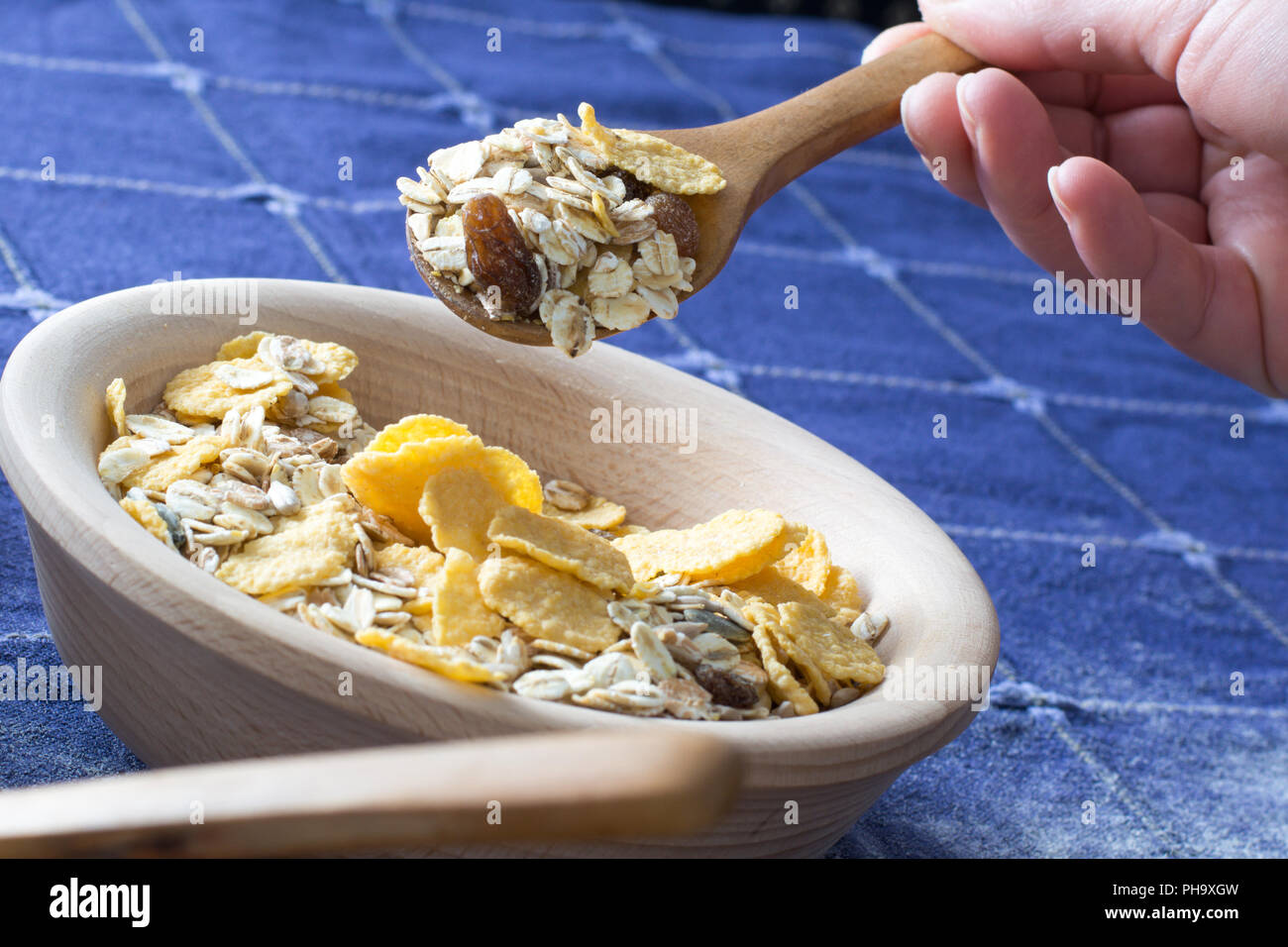 Female hand picking up cereals with wooden spoon Stock Photo Alamy