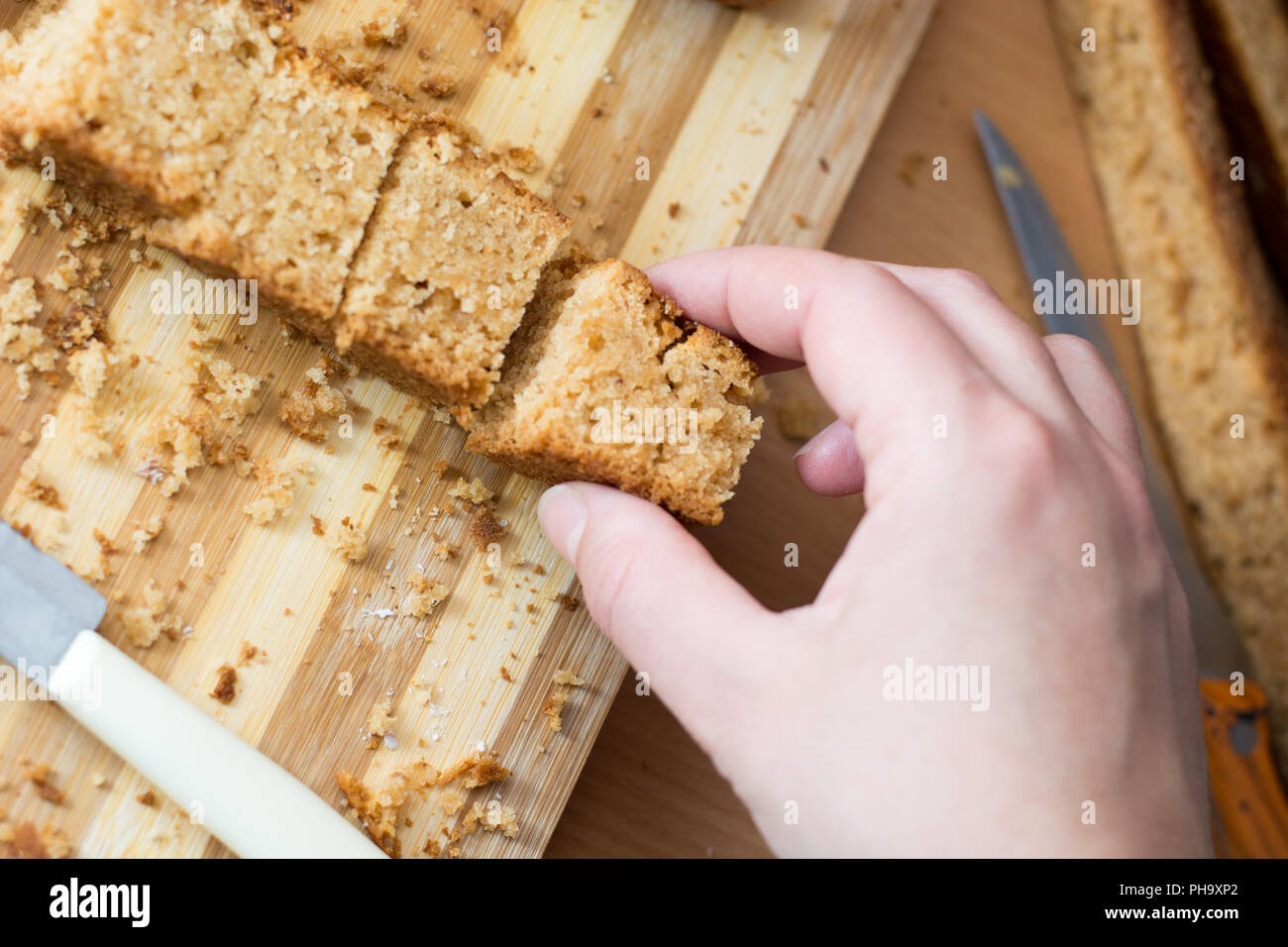Female hands cutting and preparing cake crust Stock Photo