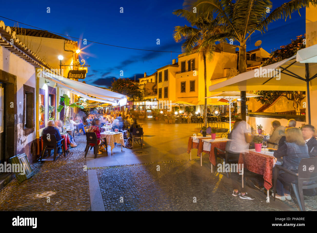 View of cafe in cobbled street in old town at dusk, Funchal, Madeira, Portugal, Europe Stock Photo