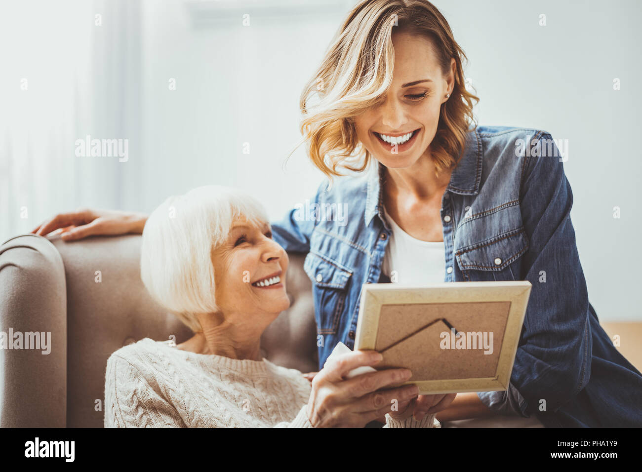 Amazing blonde woman sitting near her grandmother Stock Photo