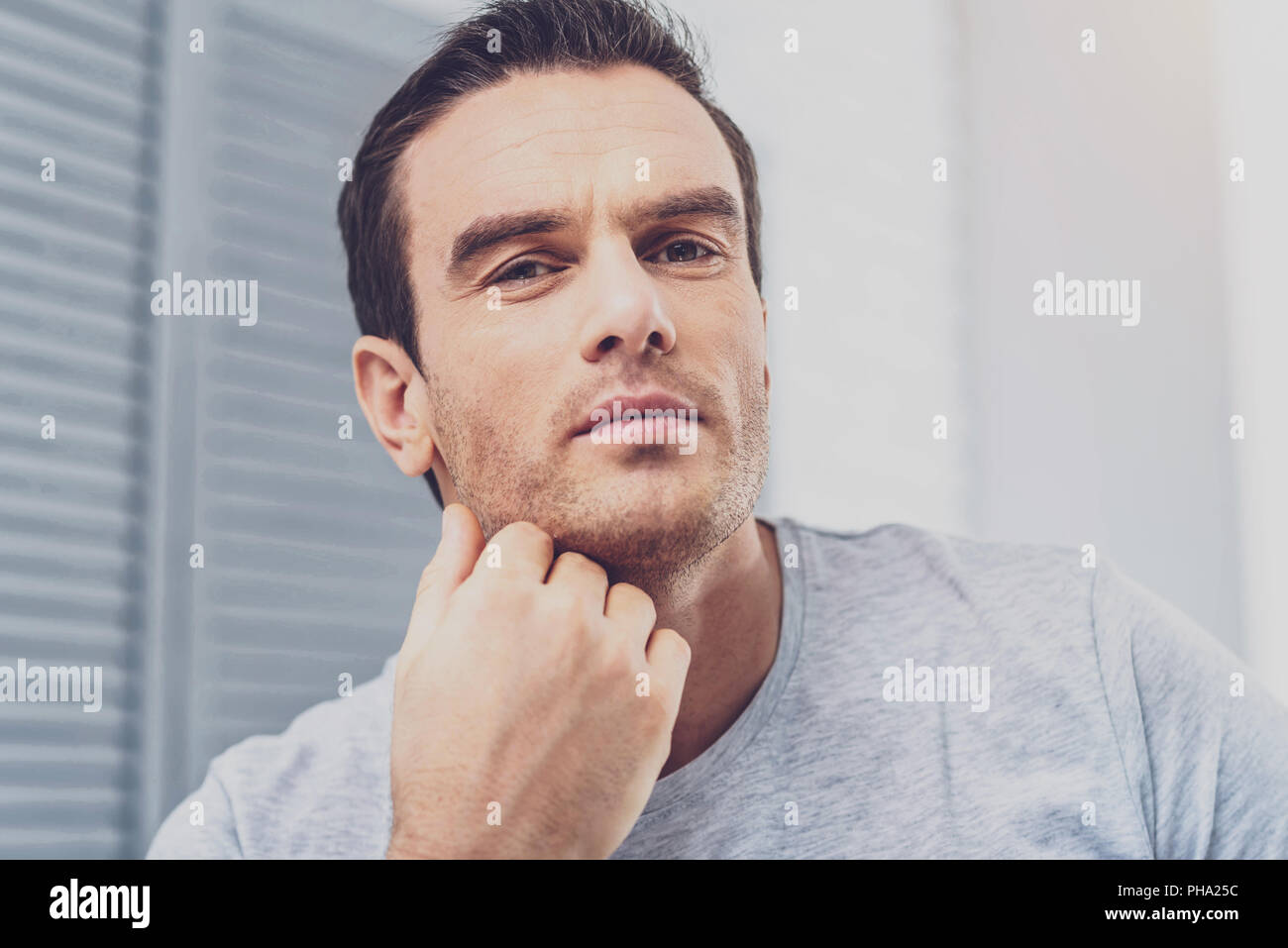 Dark-haired man feeling occupied working on business plan Stock Photo