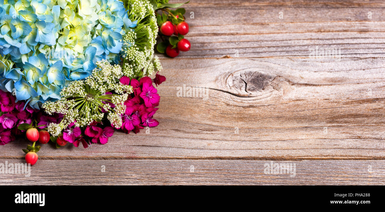 Colorful seasonal assorted flowers on stressed wood background Stock Photo