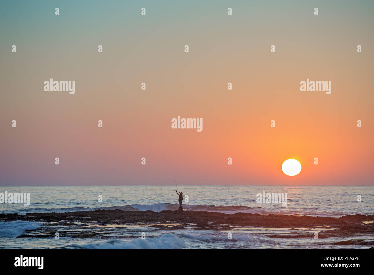 Fisherman's silhouette on seashore at sunset Stock Photo - Alamy