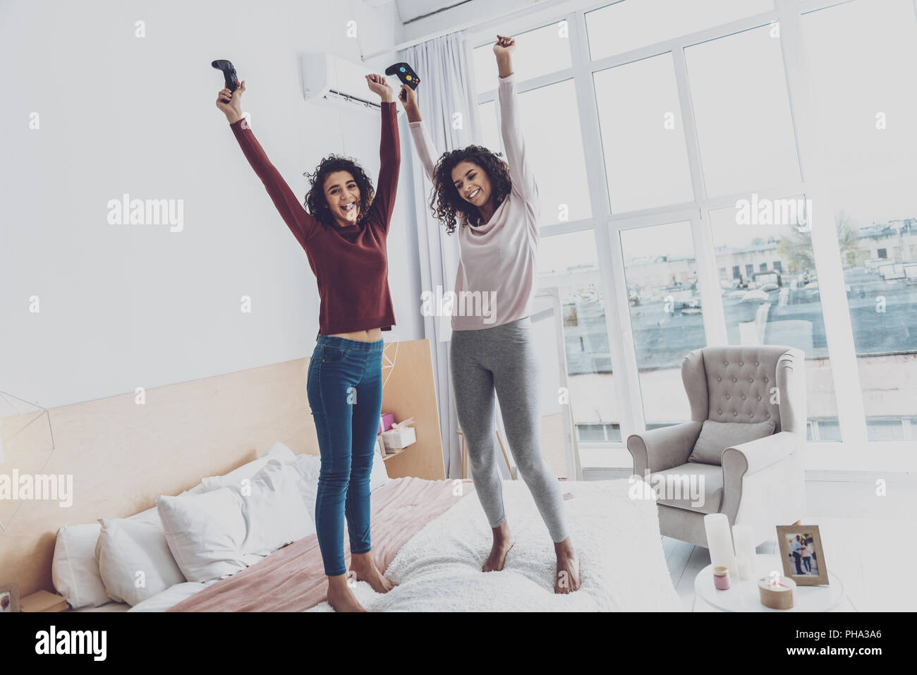 Happy girls jumping on the bed Stock Photo Alamy