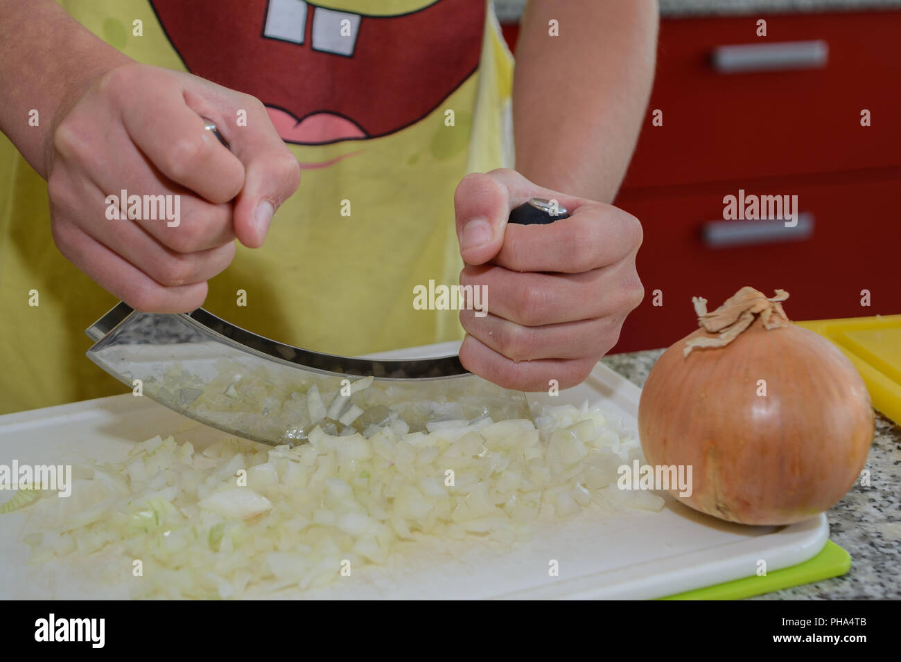 Person cuts an onion with chopping knife closeup Stock Photo Alamy
