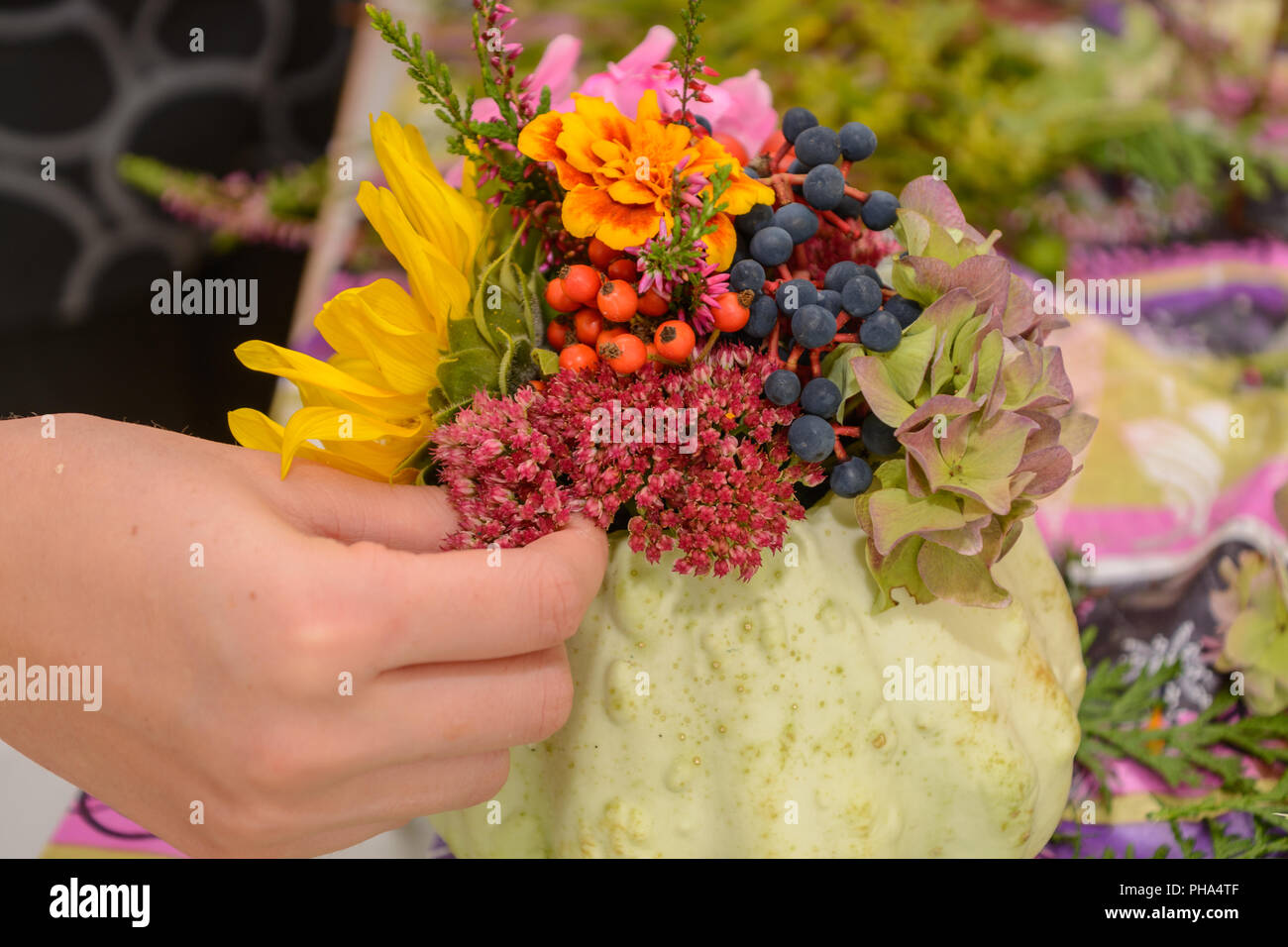 Florist designing colorful autumn arrangement from flowers - close-up Stock Photo
