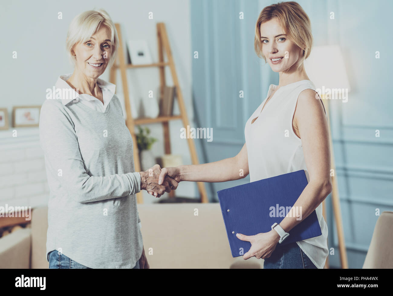 Nice joyful women shaking hands Stock Photo - Alamy