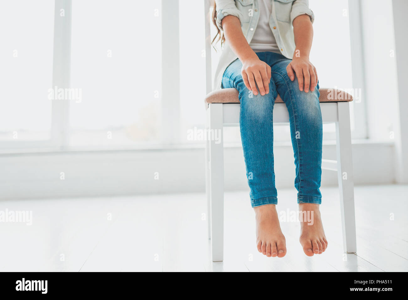 Little cute girl sitting on big wooden chair Stock Photo Alamy