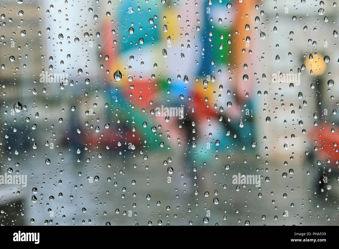 Rain water drops in a glass with a colorful background in the city Stock  Photo - Alamy