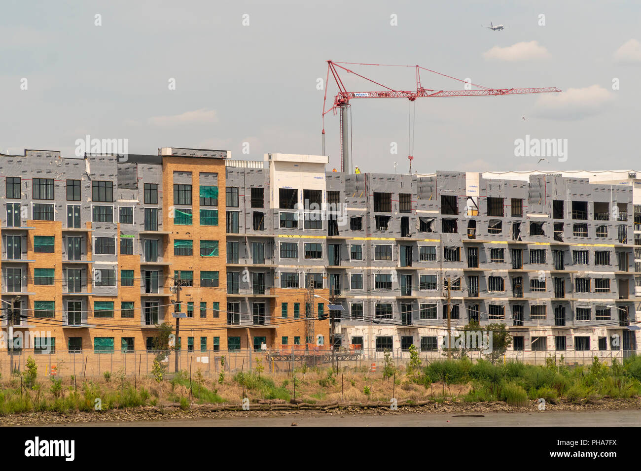 Construction of apartment buildings, in close proximity to the PATH commuter line, along the Passaic River in Harrison, NJ on Saturday, August 25, 2018.  (© Richard B. Levine) Stock Photo