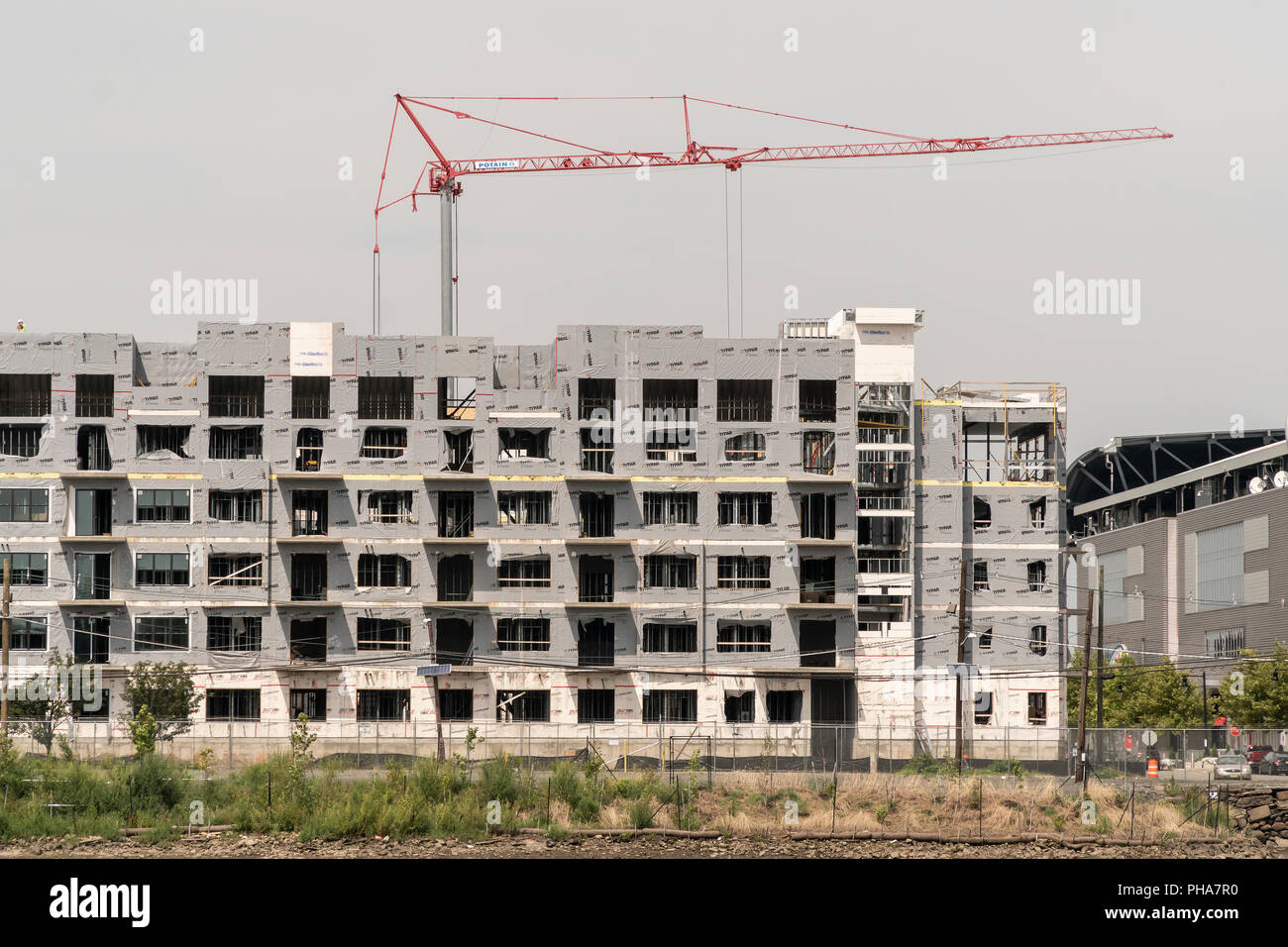 Construction of apartment buildings, in close proximity to the PATH commuter line, along the Passaic River in Harrison, NJ on Saturday, August 25, 2018.  (© Richard B. Levine) Stock Photo