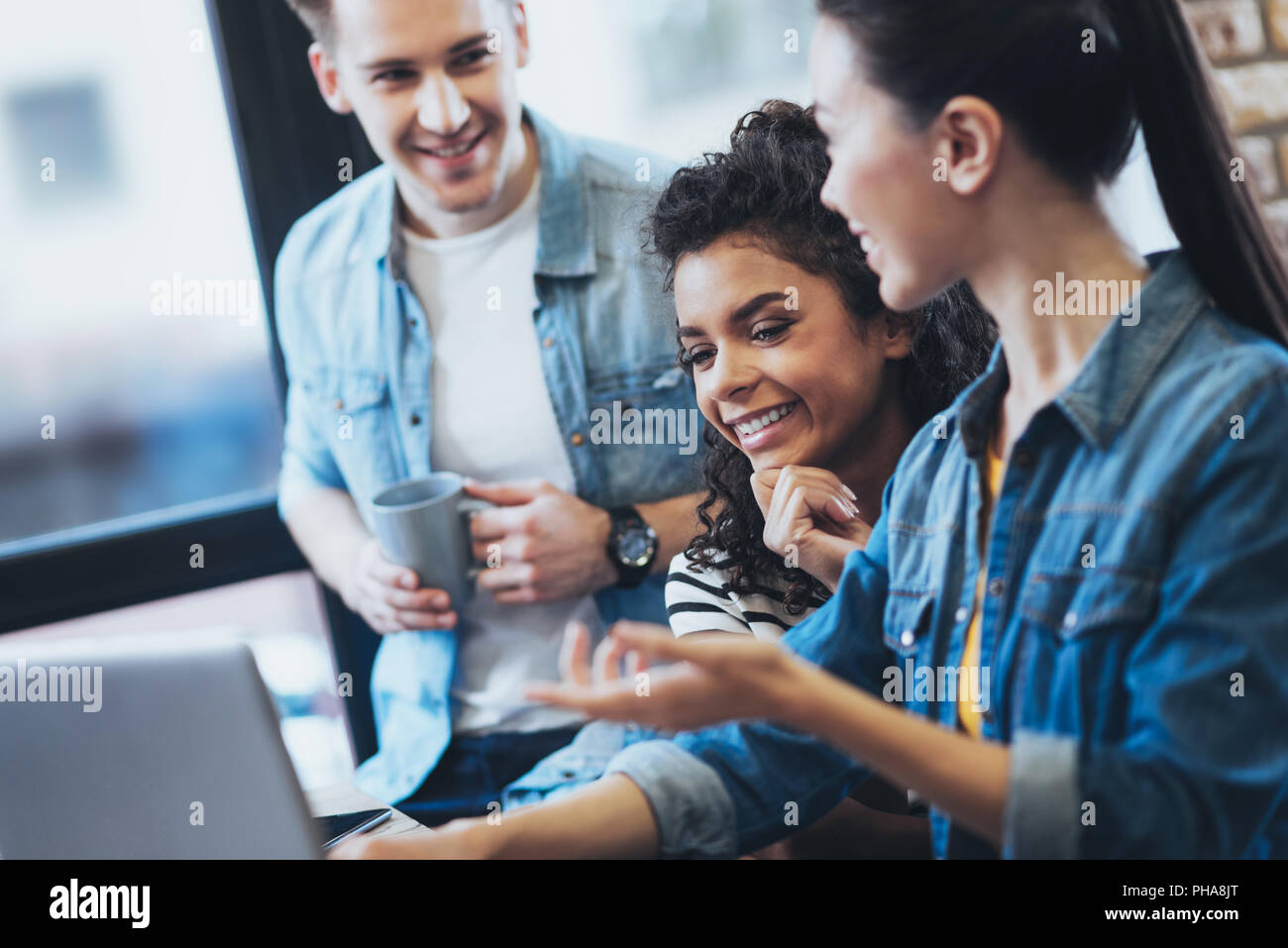 Optimistic three students collaborating on project Stock Photo