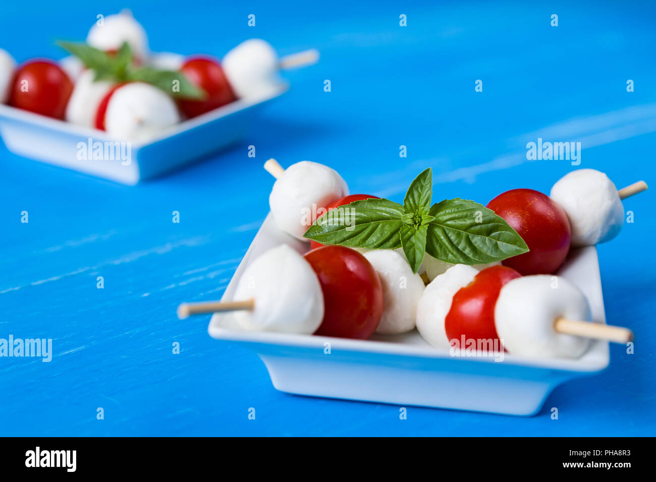 Closeup of skewers with mozzarella, cherry tomatoes and basil Stock Photo