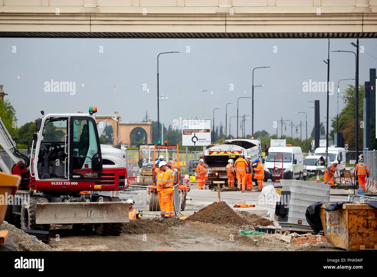 Engineers doing the groundwork laying of the Metrolink tram system passing the Trafford Centre shopping mall Stock Photo