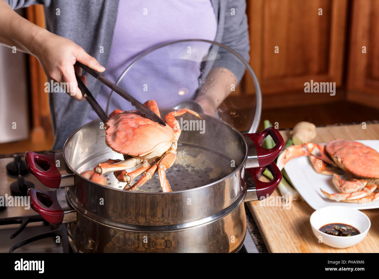 Hand removing cooked crab from steam pot Stock Photo