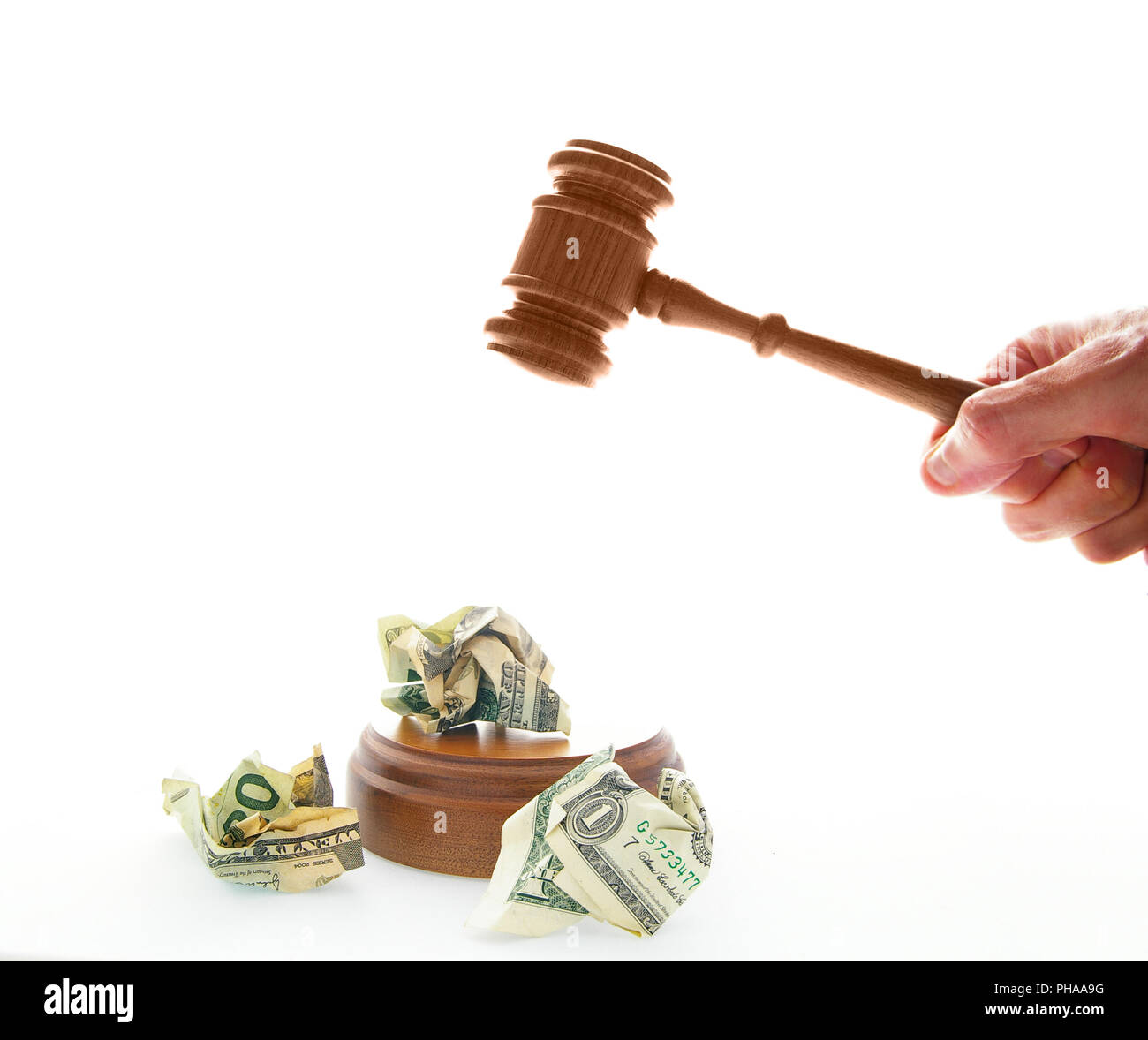 pounding a legal gavel on crumpled cash Stock Photo
