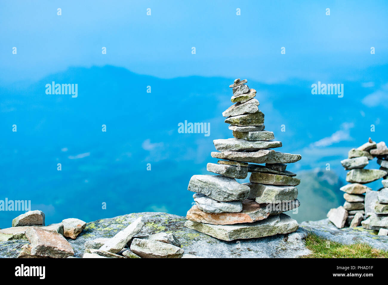 Stack of balancing stones on the top of a mountain in French Pyrenees with a view to downhills. Stock Photo