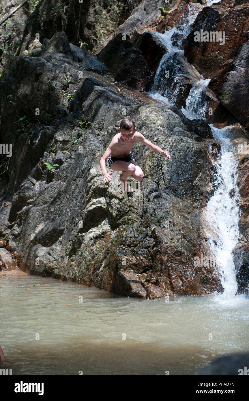 Child jumping in waterfall Stock Photo
