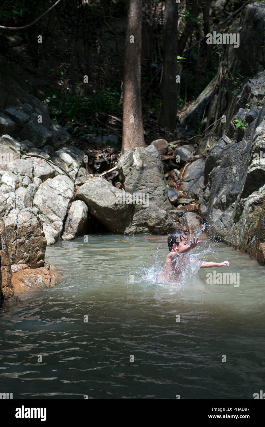 Child jumping in waterfall Stock Photo