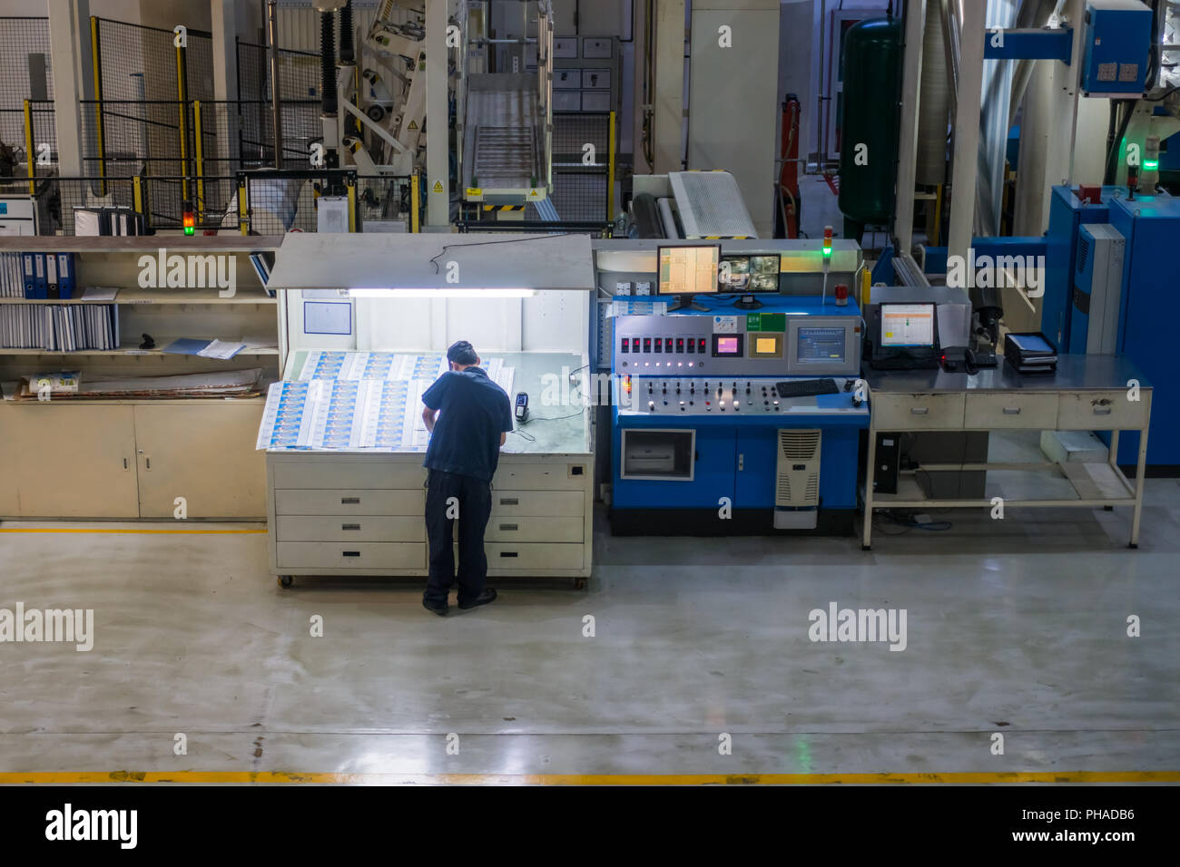 Employee Working at Printing Equipment Factory Industrial Setting Stock Photo