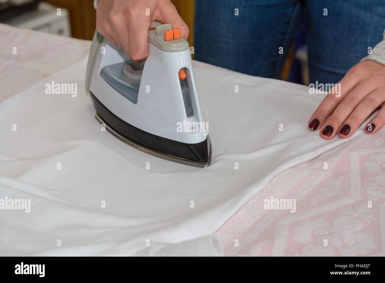 Woman ironing with steam iron on ironing board Stock Photo Alamy