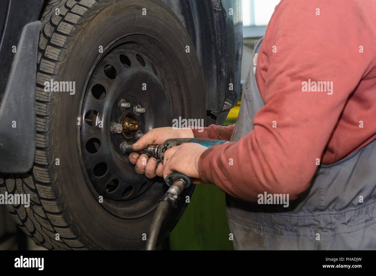 Tradesman changes with a impact driver car tire Stock Photo