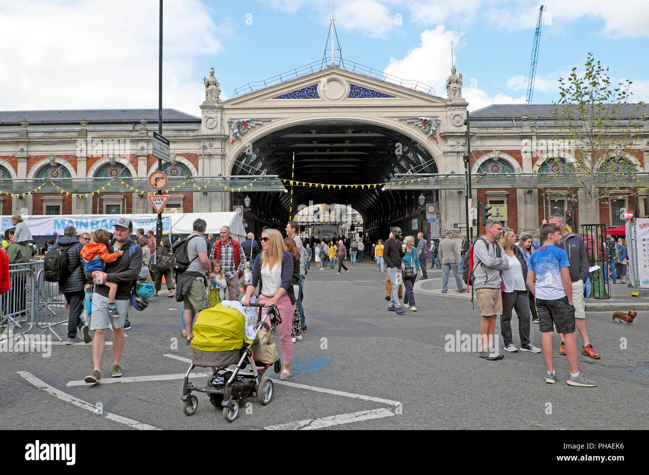 Mother pushing pram and people outside West Smithfield market building at Smithfield 150 Street Party August 2018  in London England UK  KATHY DEWITT Stock Photo