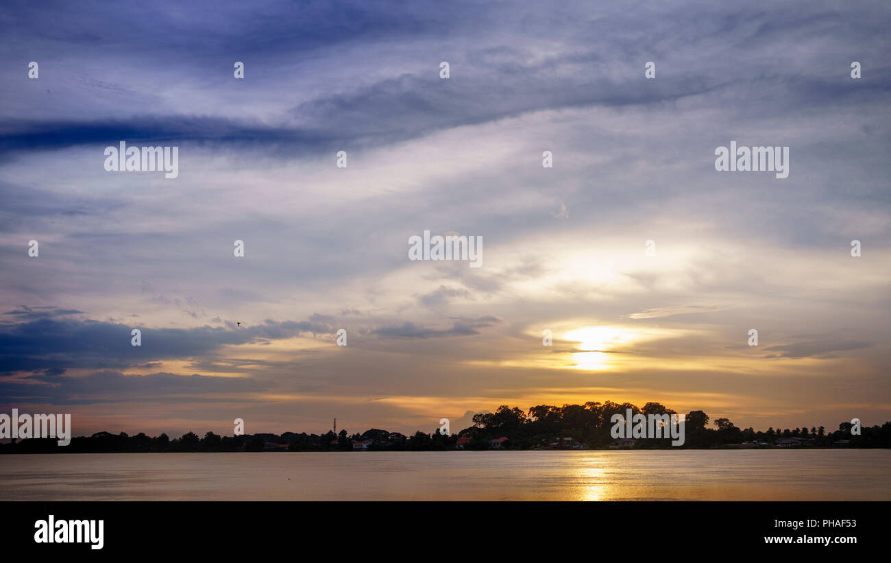 Colorful sky at sunset. Landscape sky at twilight time. Mirror sunset reflection on the water at Meakhong national river,Thailand Stock Photo