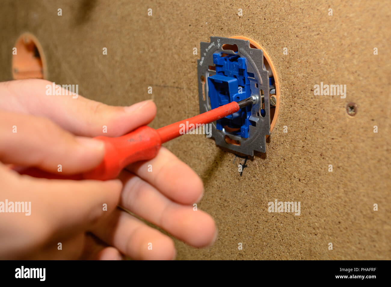 Electrical engineer installing switch at wall of installation - close-up Stock Photo