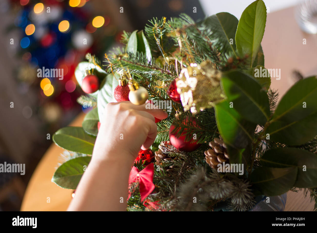 Decorating Christmass bouqet  with red ornaments and tree branches Stock Photo
