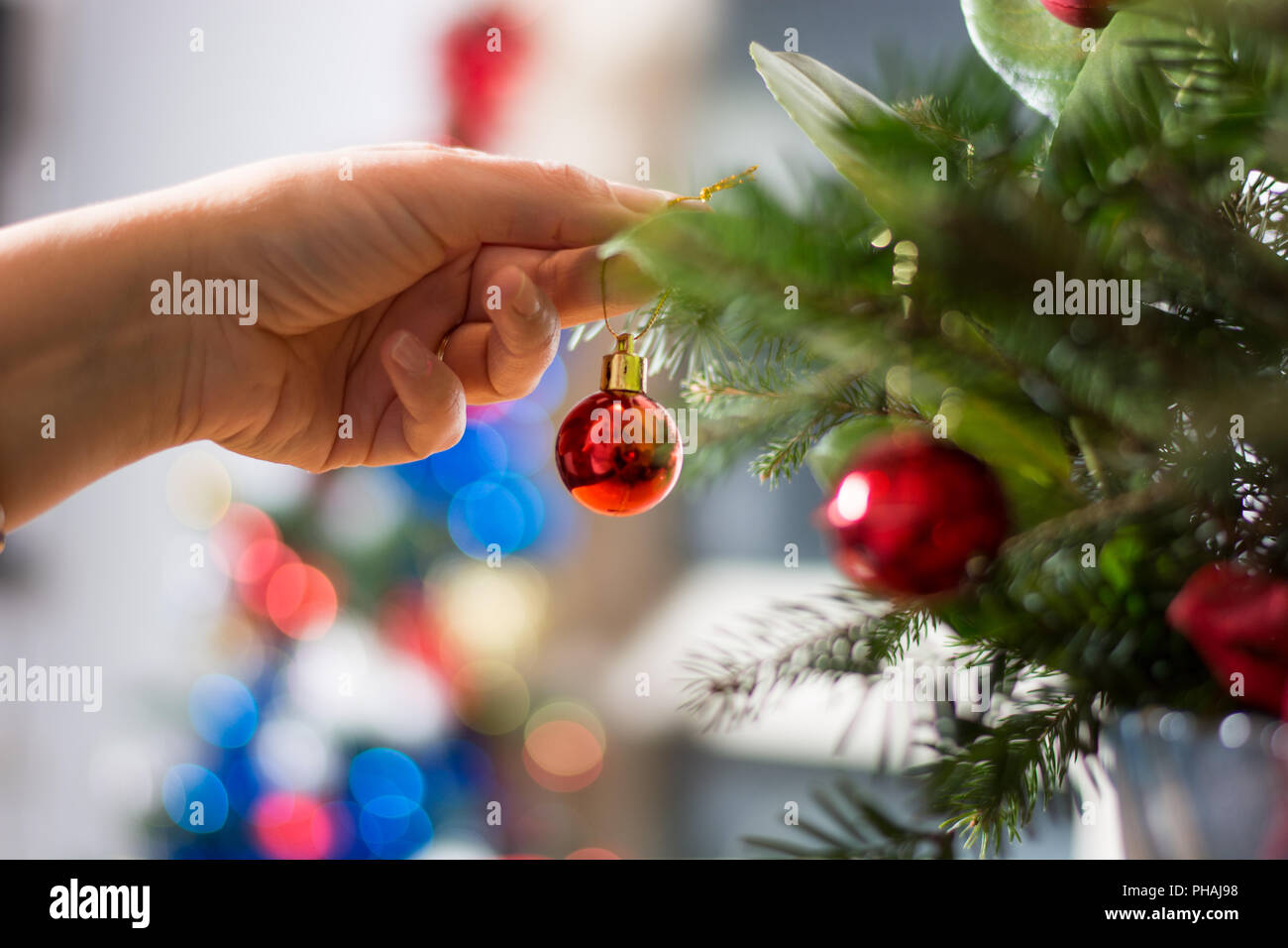 Decorating Christmass bouqet  with red ornaments and tree branches Stock Photo
